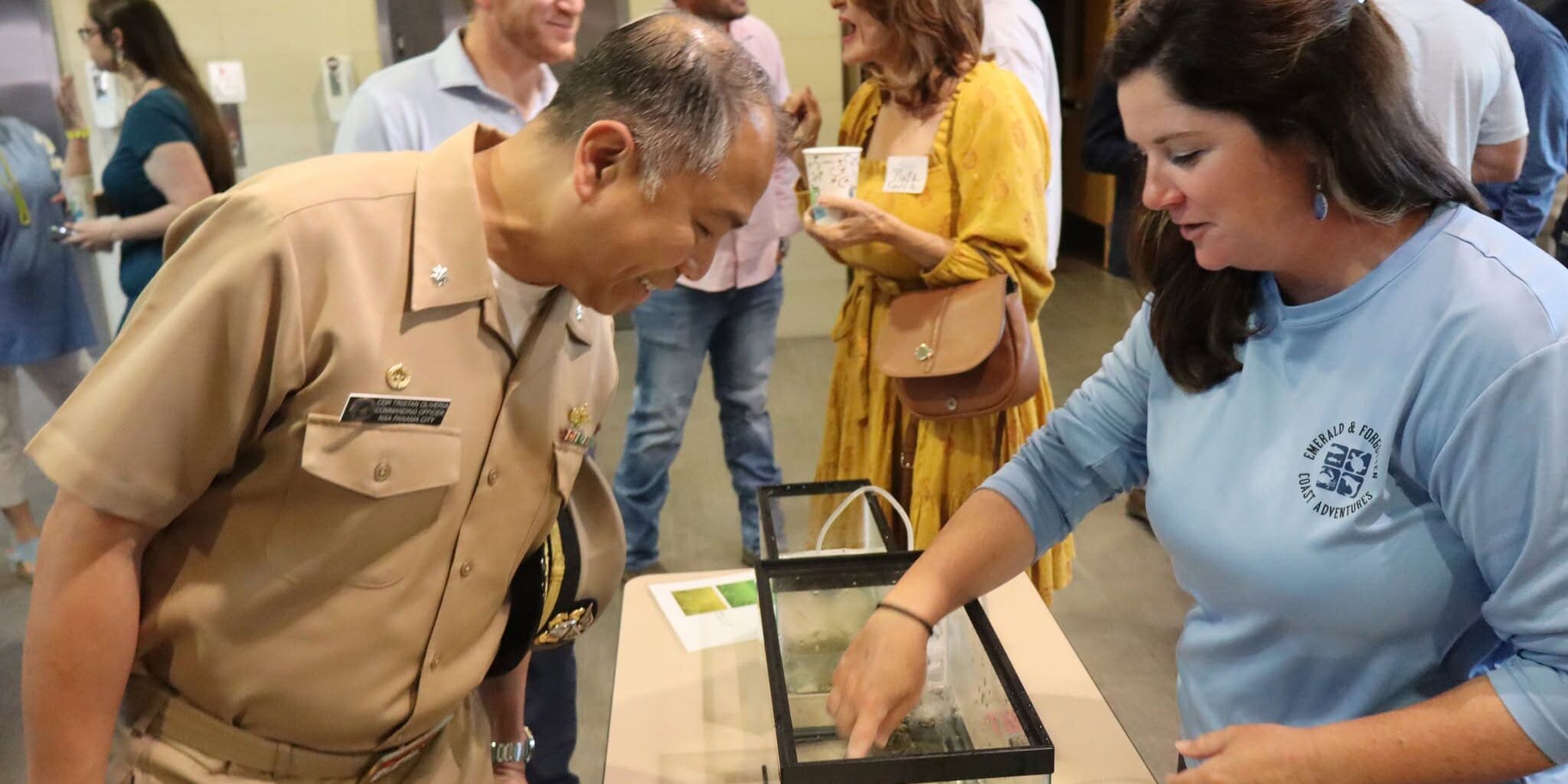 Bay County tourism representative sharing an educational display with a community member